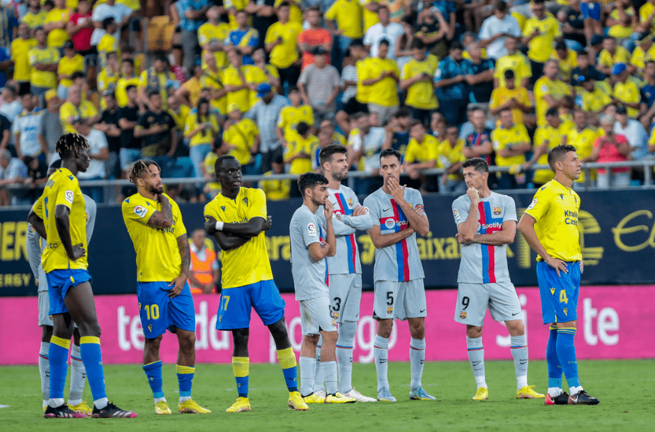 Các cầu thủ Cadiz trong trang phục áo vàng đang đứng cạnh các cầu thủ Barca trong một trận đối đầu - (Kubet cập nhật) 