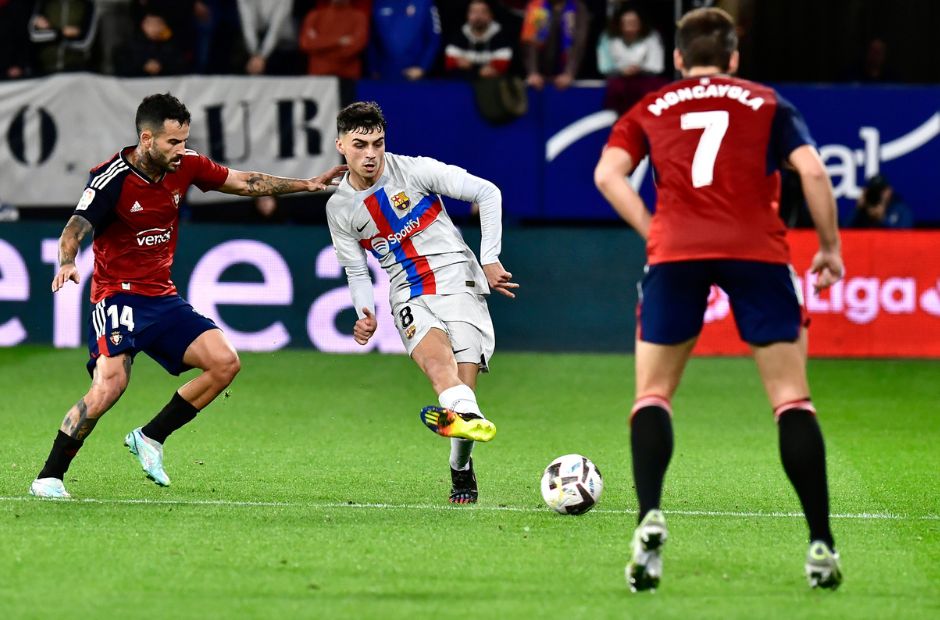 Các cầu thủ Osasuna trong trang phục màu áo bã trầu đang vây công một cầu thủ của Barca 