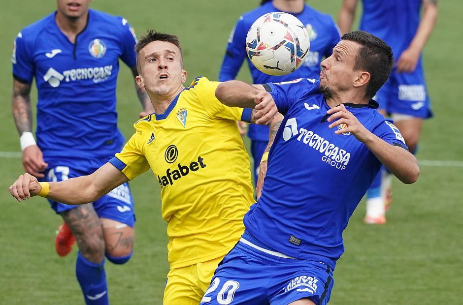 Pemain Getafe berbaju biru bersaing memperebutkan bola dengan pemain Cadiz