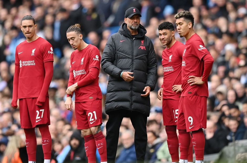Các cầu thủ Liverpool đang đứng cùng HLV Klopp người mặc áo khoác đen