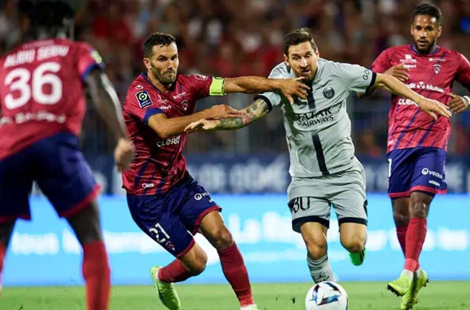 Các cầu thủ Clermont trong màu áo đỏ, đang ngăn chặn một pha đi bóng của tiền đạo Messi bên phía PSG.