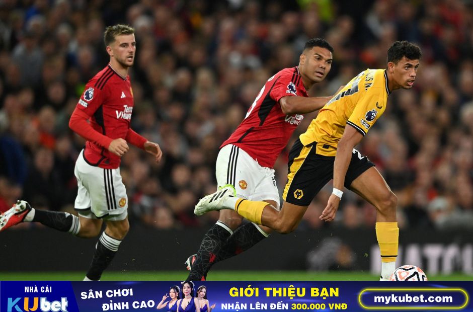 Kubet cập nhật- 2 cầu thủ Man Utd trong trang phục áo đỏ đang ngăn chặn một pha tấn công của cầu thủ áo vàng bên phía Wolves.