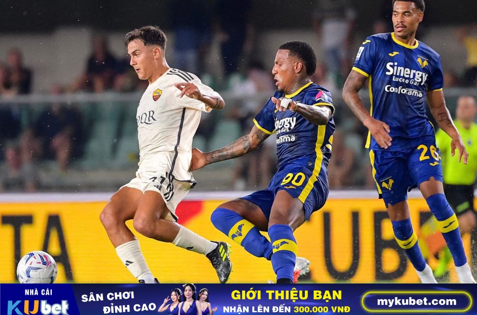 Kubet cập nhật hình ảnh Dybala trong trang phục màu trắng của AS Roma đang bị hậu vệ bên phía Verona truy cản.
