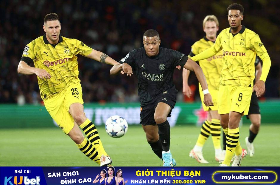 Kubet cập nhật hình ảnh các cầu thủ Dortmund trong trang phục màu vàng truyền thống đang ngăn chặn pha đi bóng của Mbappe bên phía PSG 
