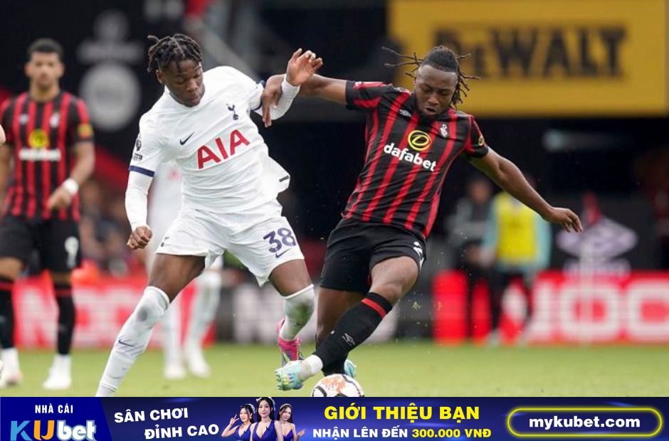 Kubet cập nhật hình ảnh cầu thủ Bournemouth trong trang phục áo kẻ sọc đỏ-đen đang tranh bóng với cầu thủ Tottenham 