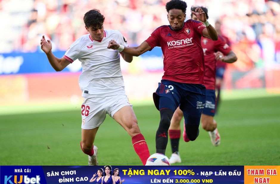 Kubet cập nhật hình ảnh cầu thủ Osasuna trong trang phục áo bã trầu đang tranh bóng cùng cầu thủ bên phía Sevilla quần áo trắng trong một trận đấu tại La Liga 