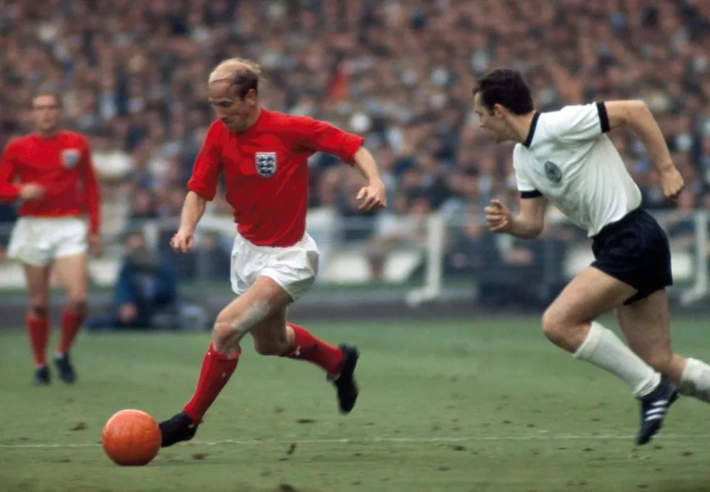 Bobby Charlton của Anh (trái) chuyền bóng qua Franz Beckenbauer trong trận chung kết World Cup 1966 ( Hình ảnh: Kubet)